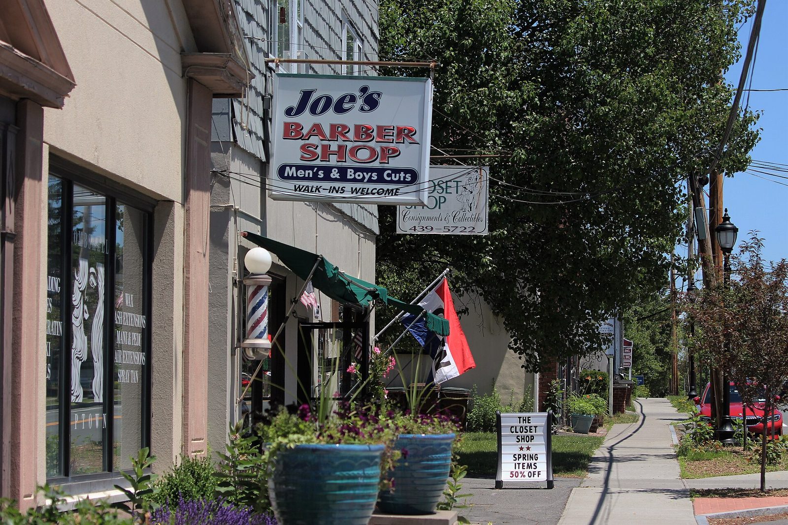 Ulice s cedulí Joe's Barber Shop a pruhovaným barber sloupem v Delmaru ve státě New York